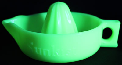 A light seville yellow straight handle Sunkist juicer under UV light