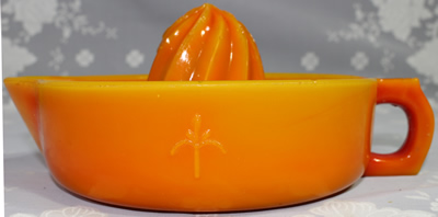 Side view of orange glass "Fleur-De-Lis" juicer