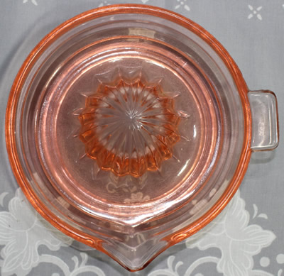Top view of a Jeannette Glass Co salmon pink juicer 