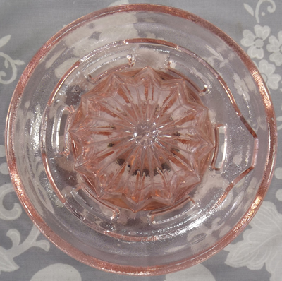Reamer for Pink glass juicer embossed with a lemon and an orange