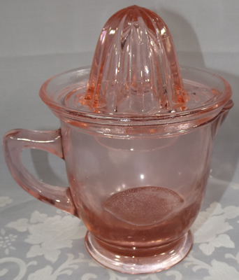 Embossed lemon on pink glass juicer embossed with a lemon and an orange