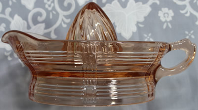 Side view of a large orange pink Hazel Atlas criss-cross juicer