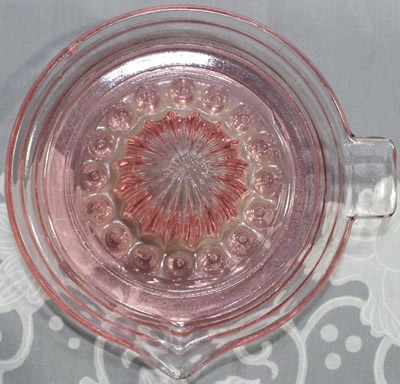 Top view of a pink Jeannette Glass Co. juicer with pip collectors