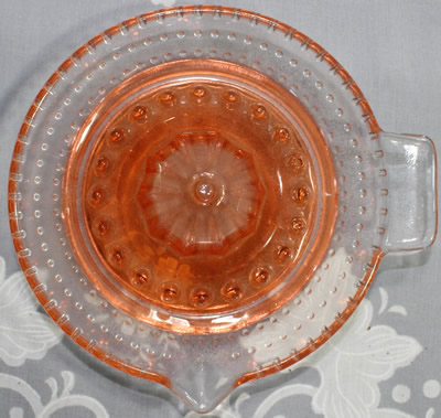Top view of an ARC pink and clear glass hobnail juicer