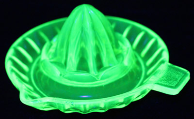 A yellow uranium saucer reproduction juicer under UV light