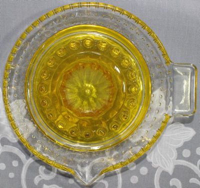 Top view of an ARC yellow and clear glass juicer