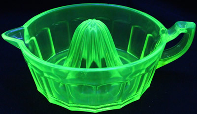 A large Summit Art Glass yellow (Uranium) juicer under UV light
