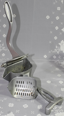 An open powder coated aluminum lever juicer showing the 3 pieces 