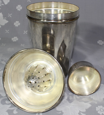 The 3 parts of a hallmarked M.A. silverplate cocktail shaker with juicer