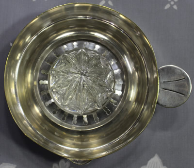 Top view of a French 3 piece glass reamer on a silverplate saucer juicer