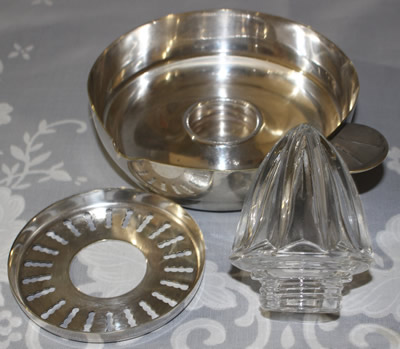 The 3 parts of a French 3 piece glass reamer on a silverplate saucer juicer