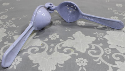 An open small blue painted hand press juicer