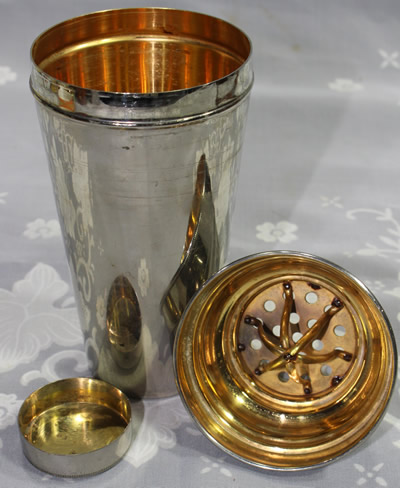 An open German 3 piece chrome plated cocktail shaker set with a juicer
