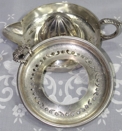 The 2 parts of a silverplate stars and crescent moon strainer juicer