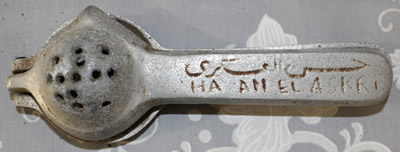 An inscription 'HA AN EL ASKRI' on an aluminium squeezer juicer 