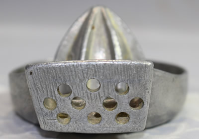 The front drainholes on an aluminium saucer shape juicer with a side mounted drain