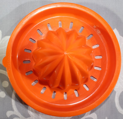 Top view of an orange Tupperware juicer insert