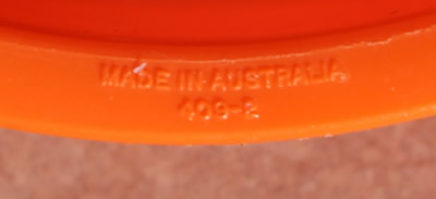The embossed manufacture details on an orange Tupperware juicer insert 