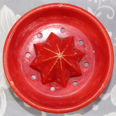 The reamer for a red plastic Moldex Australia juicer on clear base