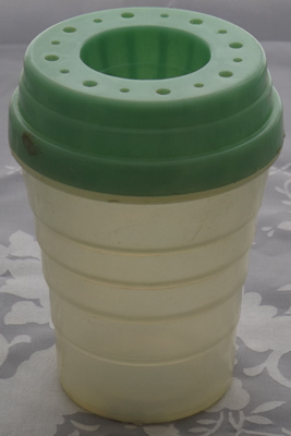 Green juicer on white translucent plastic tumbler