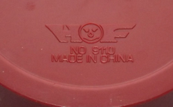The embossed base of a maroon and cream push juicer