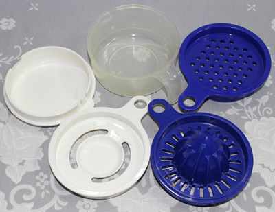 The parts of complete set including the small blue tupperware juicer 