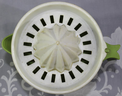 Top view of an olive green and white notched juicer showing the notch 