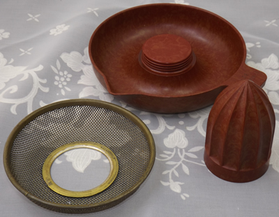 3 parts of a brown & red mottled bakelite juicer