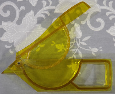 An open transparent yellow plastic bird wedge squeezer juicer 