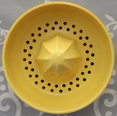 Top view of a yellow Australian cocktail shaker juicer top