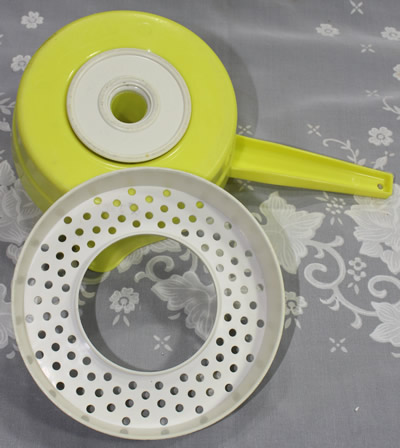 Showing the rotating base and strainer for a Yellow and white Florida citrus juicer