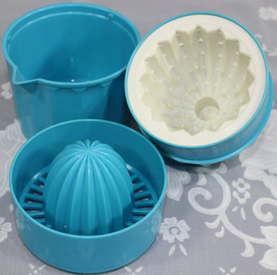 Parts of a Blue and white 3 piece plastic squeezer juicer