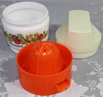 The 3 parts of a Gemco orange plastic on white milk glass juicer