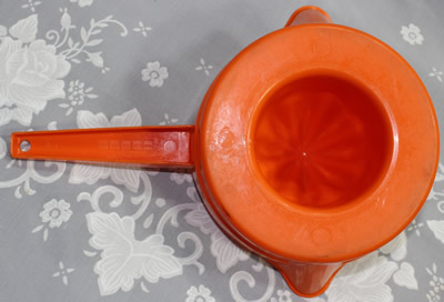 The base of an orange and yellow Decor plastic pot shape juicer