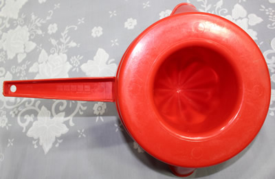 The base of a red and white Decor plastic pot shape juicer