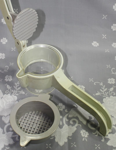 An open cream, grey and clear press plastic press juicer