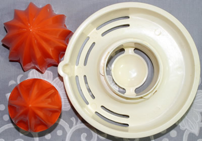 The 3 parts for the top of a Heimag red and white plastic juicer