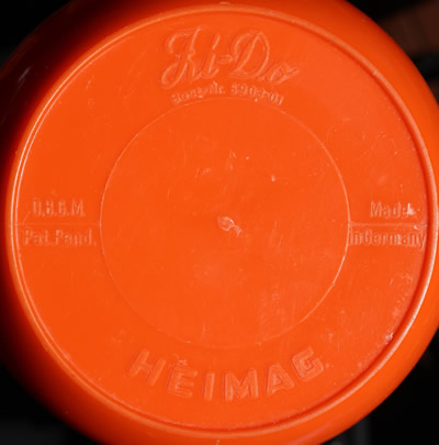 The embossed base of a Heimag 4 piece red and white plastic juicer
