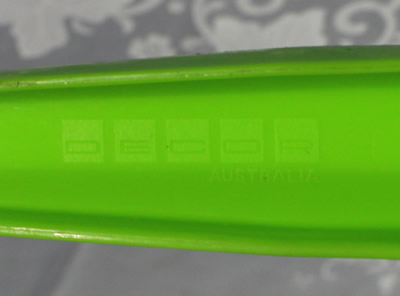 The Decor logo on a lime green and red plastic pot shape juicer