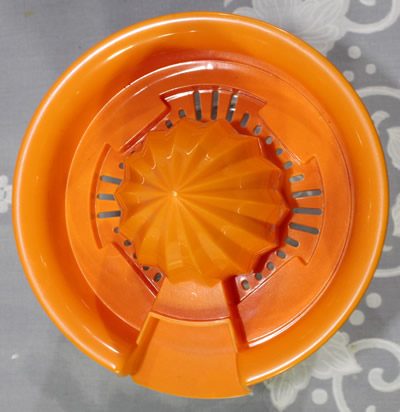 Top view of an orange plastic juicer on glass jar like Gemco