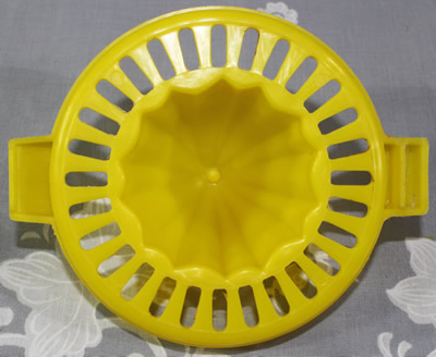 The bottom of the insert for a 2 piece Trend yellow & grey plastic juicer 