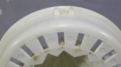 The notches on a reamer for an olive green plastic jug with white juicer