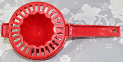 Red plastic hand held juicer
