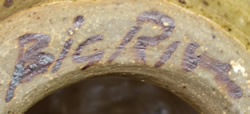 Potters mark on Loop handled hand thrown brown on tan coloured pottery juicer