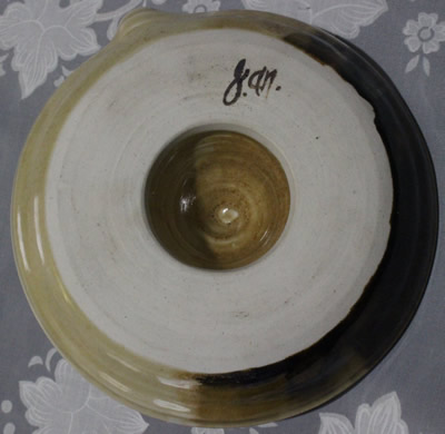 Base of a cream through to brown pottery juicer