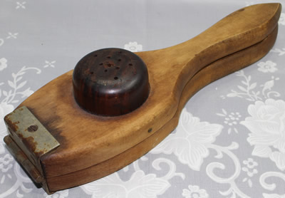 The bottom of a hinged 'Lignum Vitae' hand held squeezer