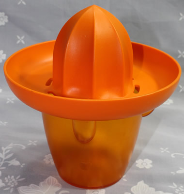 An orange Koziol 'Pedro' plastic juicer
