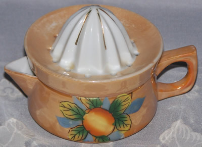 Lemon and leaves on a tan lustre ware juicer