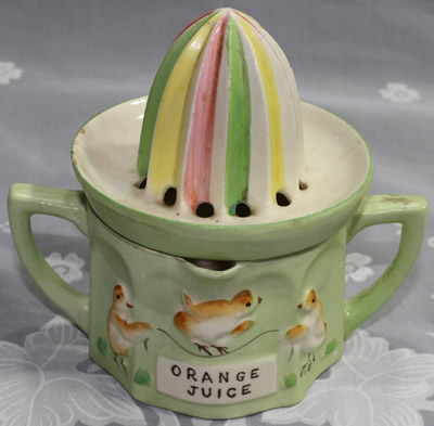 'ORANGE JUICE' and chicks on a pale green jug juicer