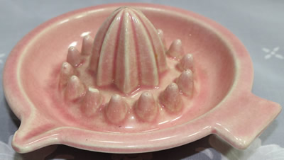 A 1 piece pink saucer shape ceramic juicer